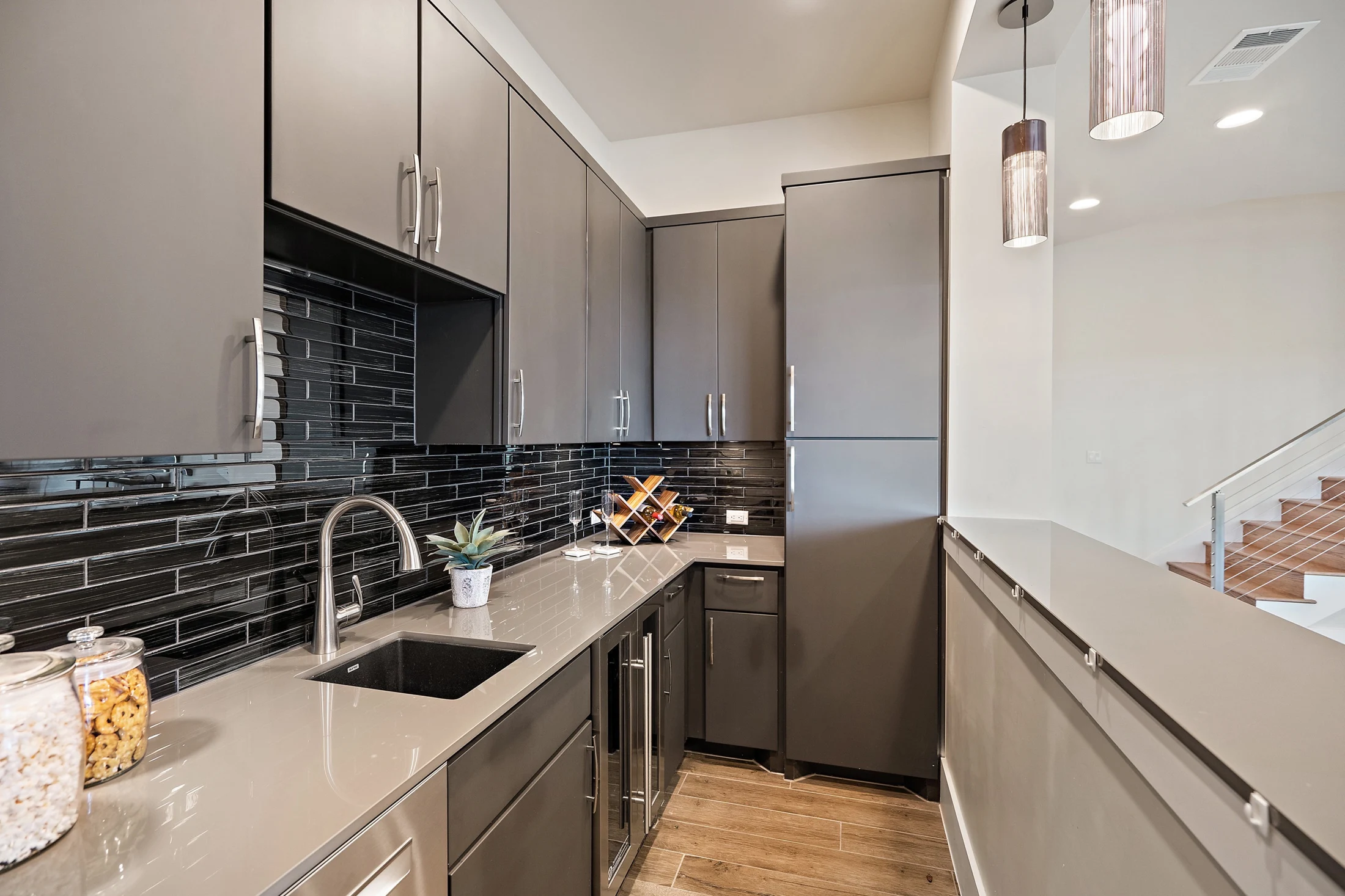 Custom wet bar with dark tile and built-in cabinetry