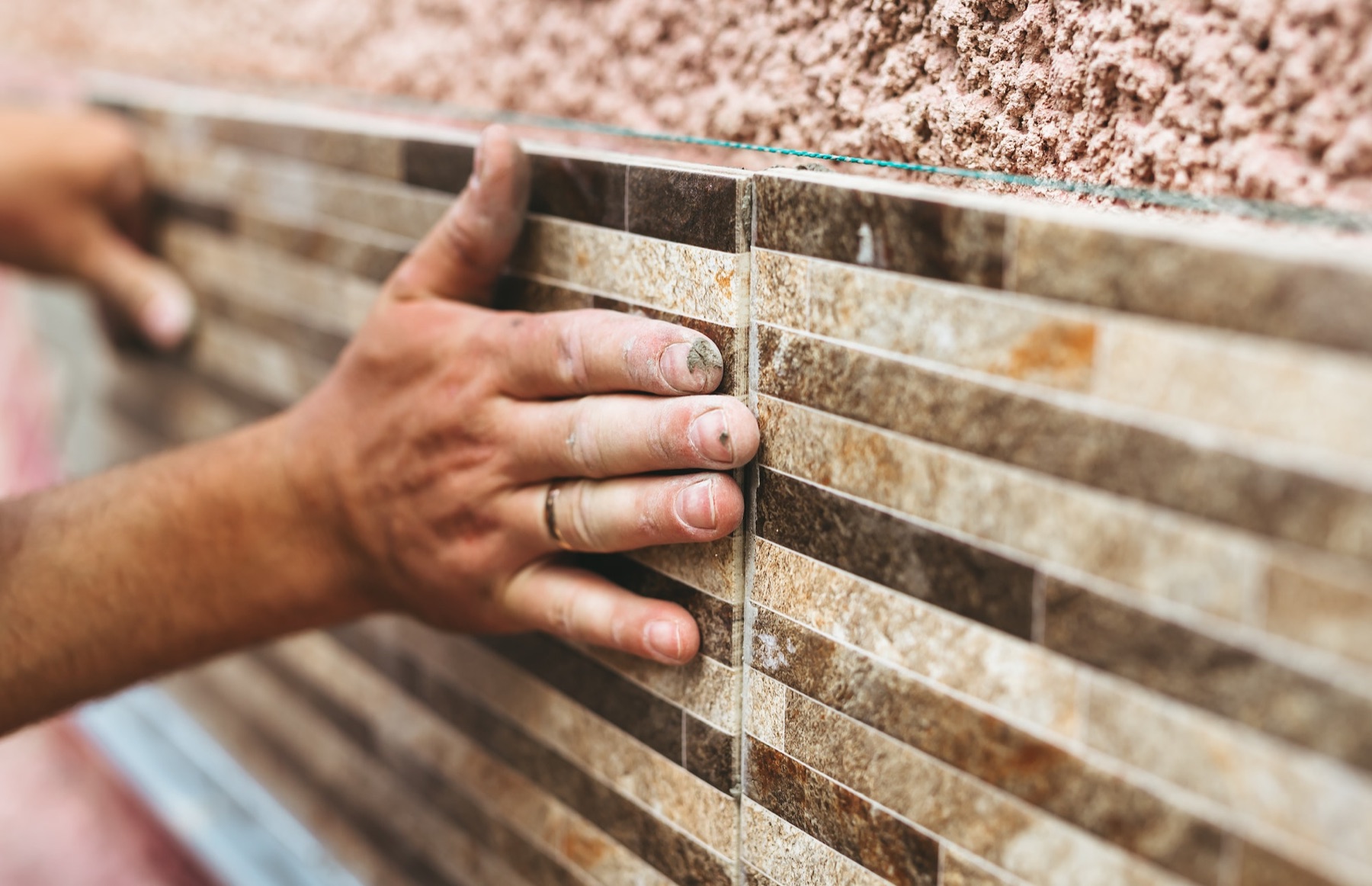 Craftsperson aligning finish tile during construction