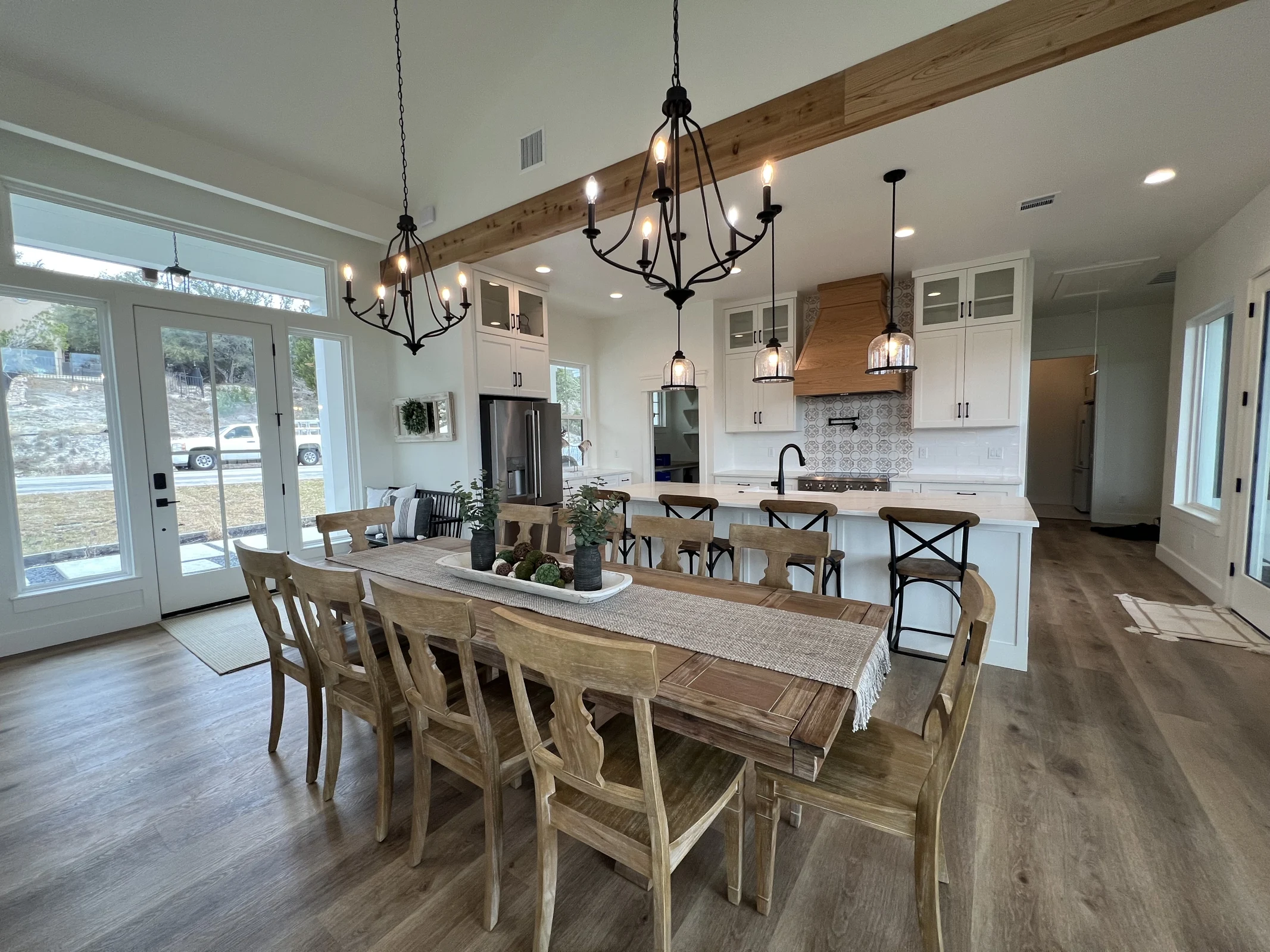 Dining room with long wood table beside an open kitchen