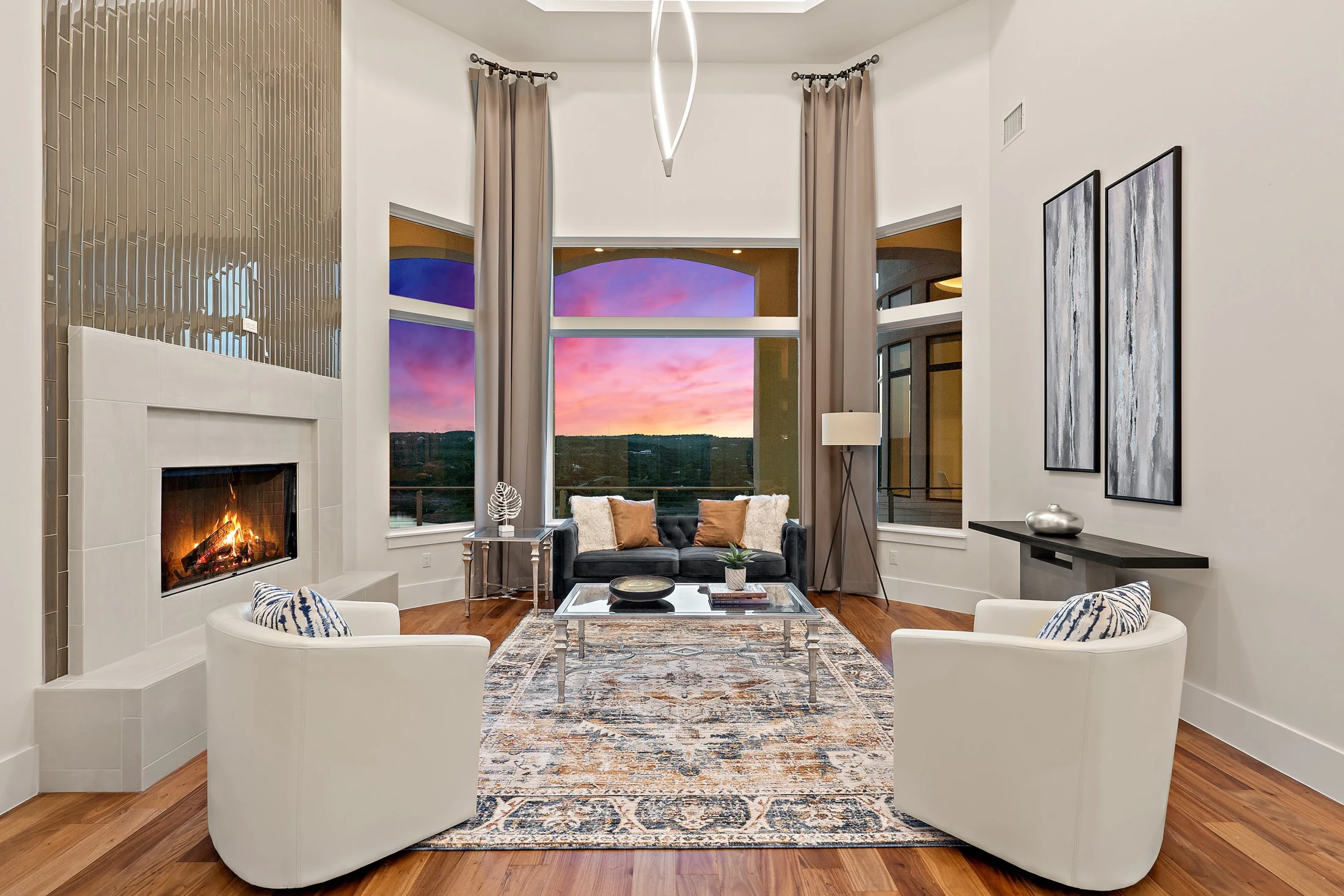 A welcoming living room centered around a fireplace with sunset views