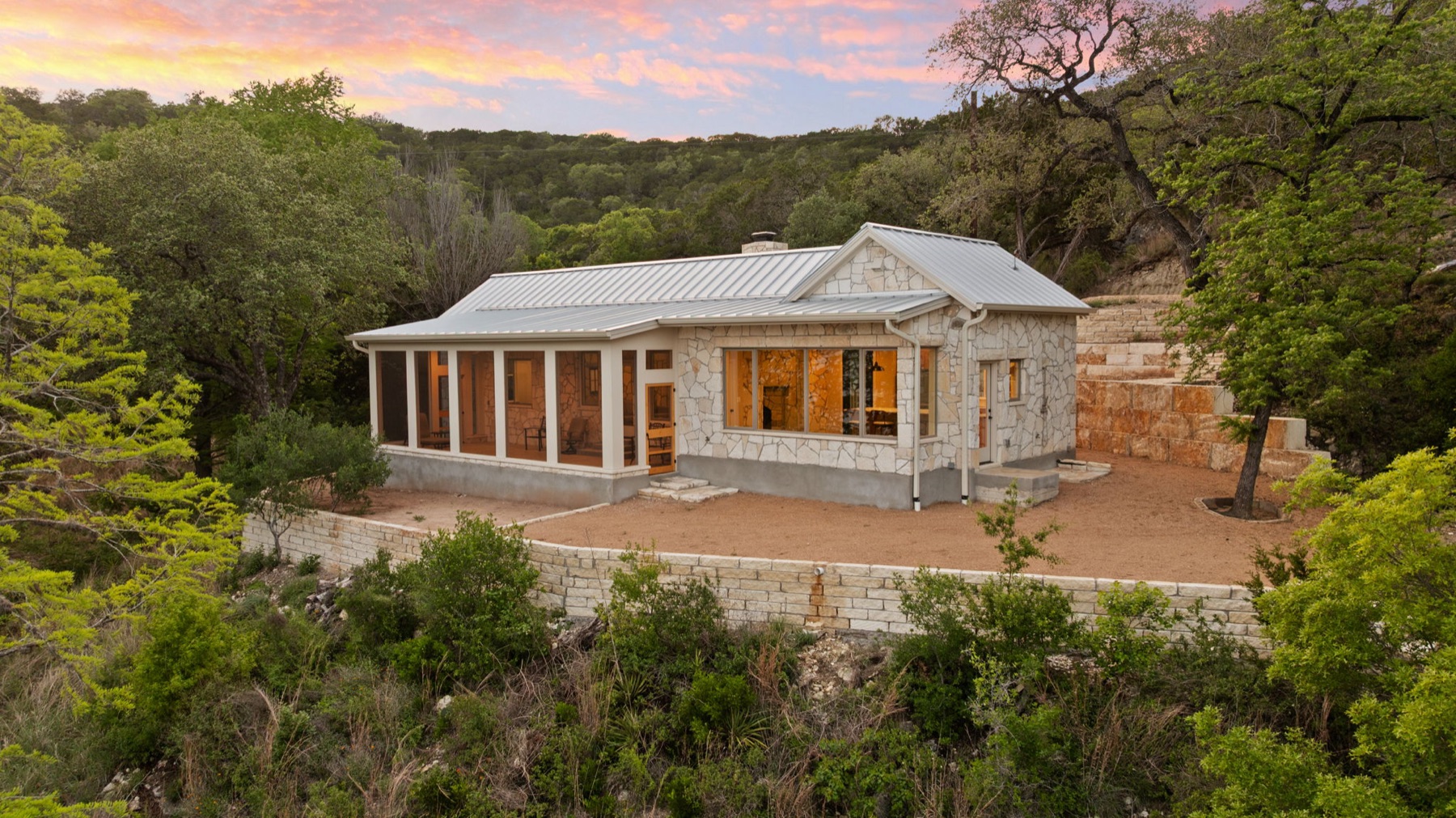 Aerial view of the home settled into its wooded Lake Travis site