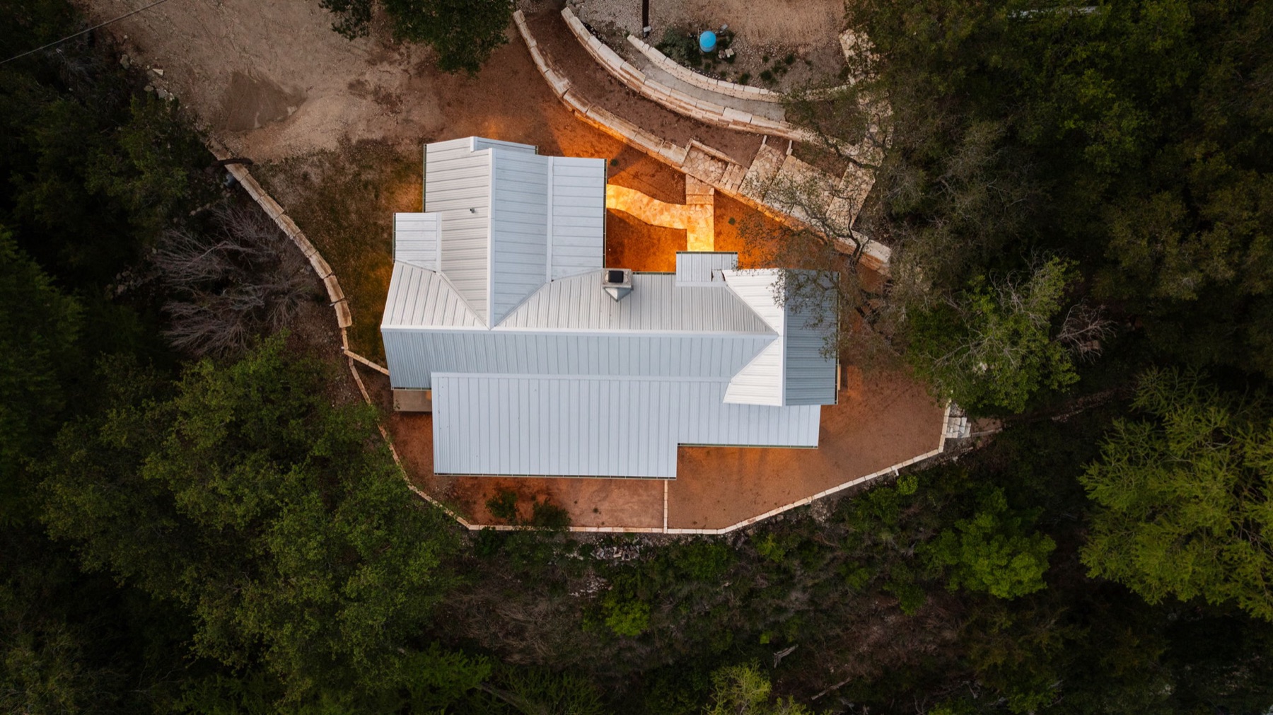 Overhead view showing a custom home placed within its wooded homesite
