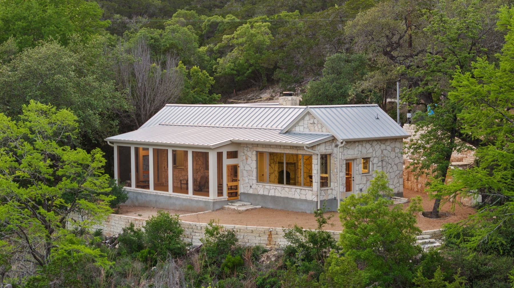 Lakeside retreat aligned with its surrounding trees and topography