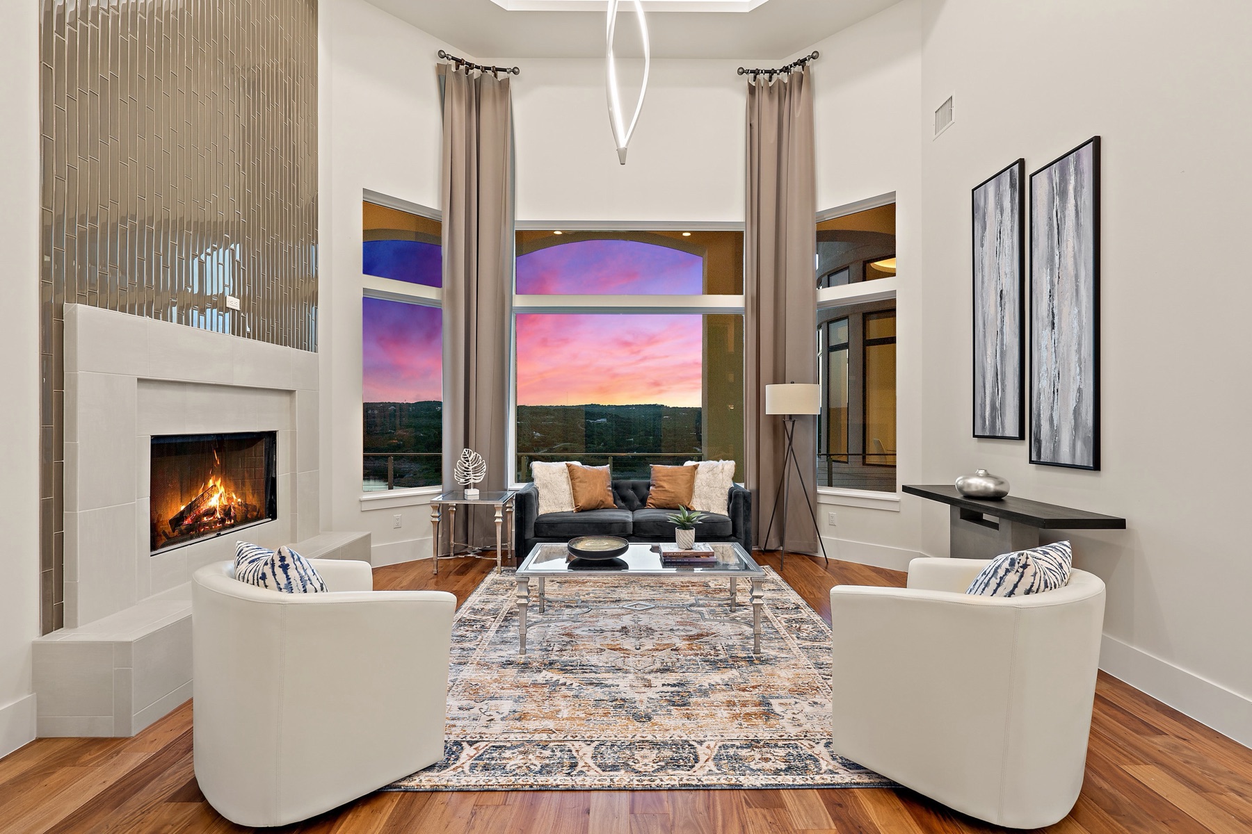 Custom living room centered on a fireplace and sunset view